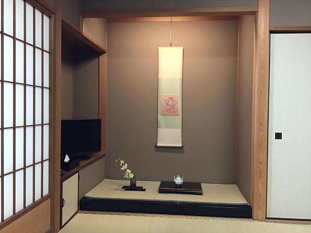 a living room with a table and a television at Kyonoyado Kagihei in Kyoto