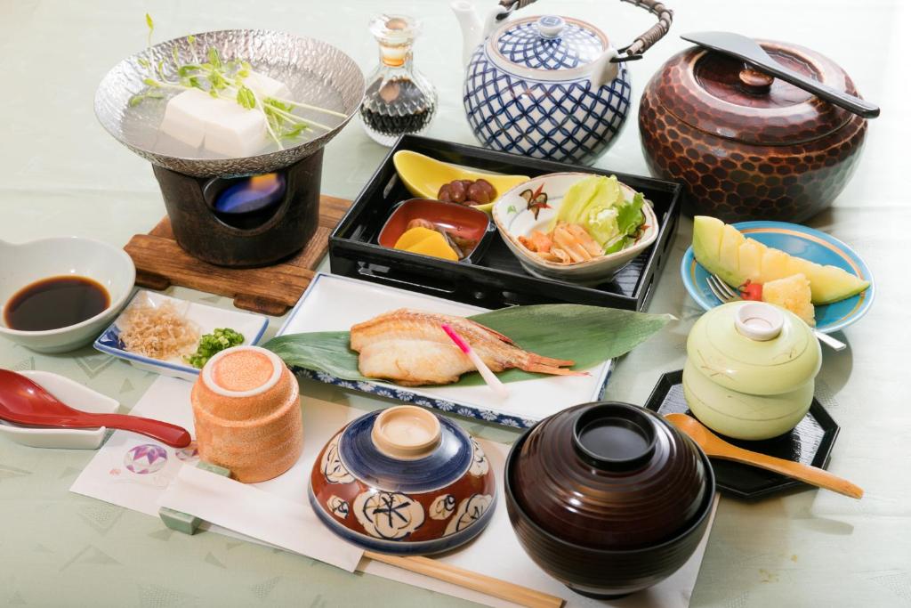 a table topped with bowls and plates of food at Kyonoyado Kagihei in Kyoto