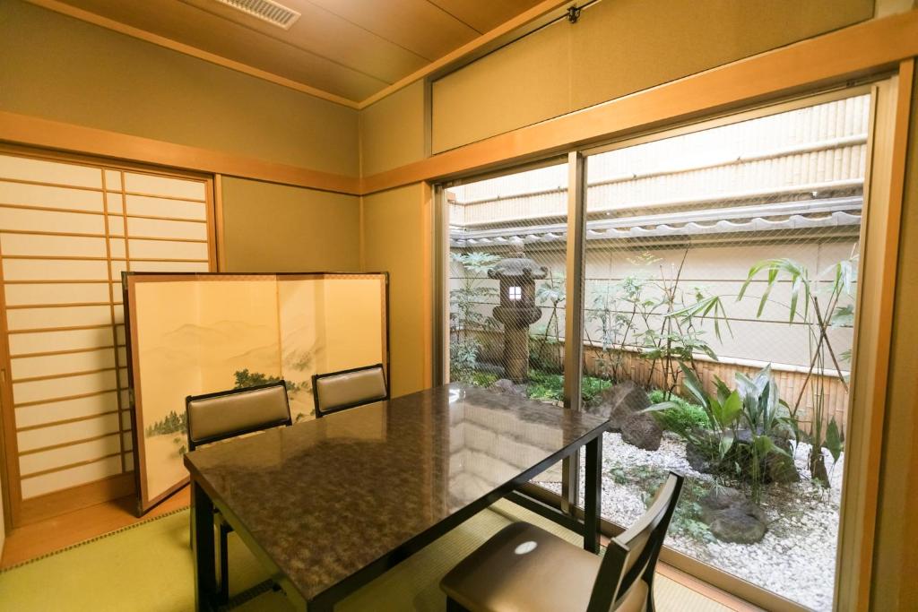 a dining room with a table and a large window at Kyonoyado Kagihei in Kyoto