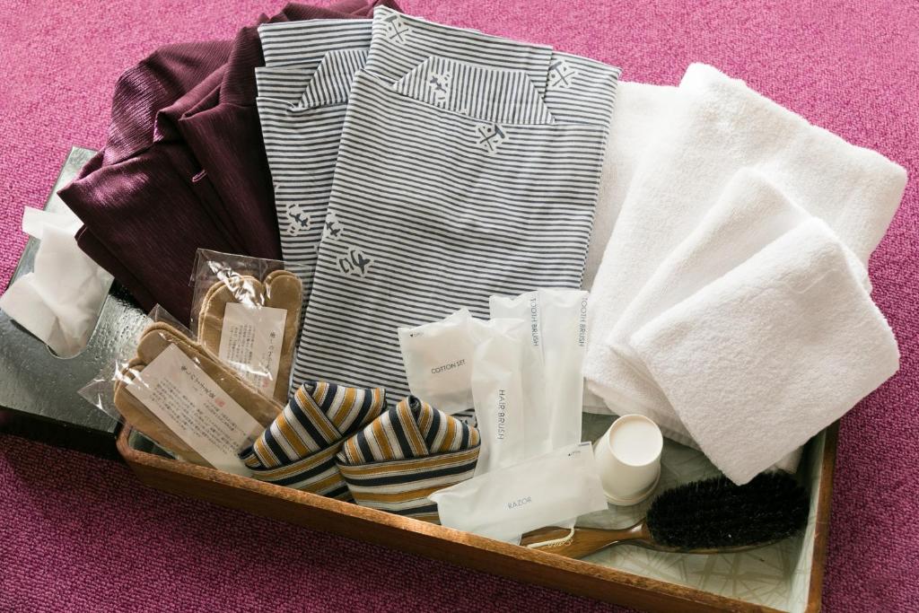 a suitcase filled with clothes and towels on a table at Kyonoyado Kagihei in Kyoto
