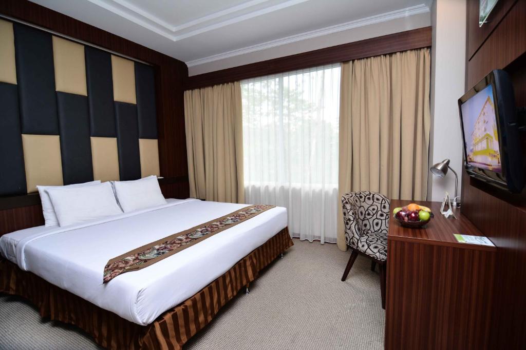 Postel nebo postele na pokoji v ubytování Angkasa Garden Hotel