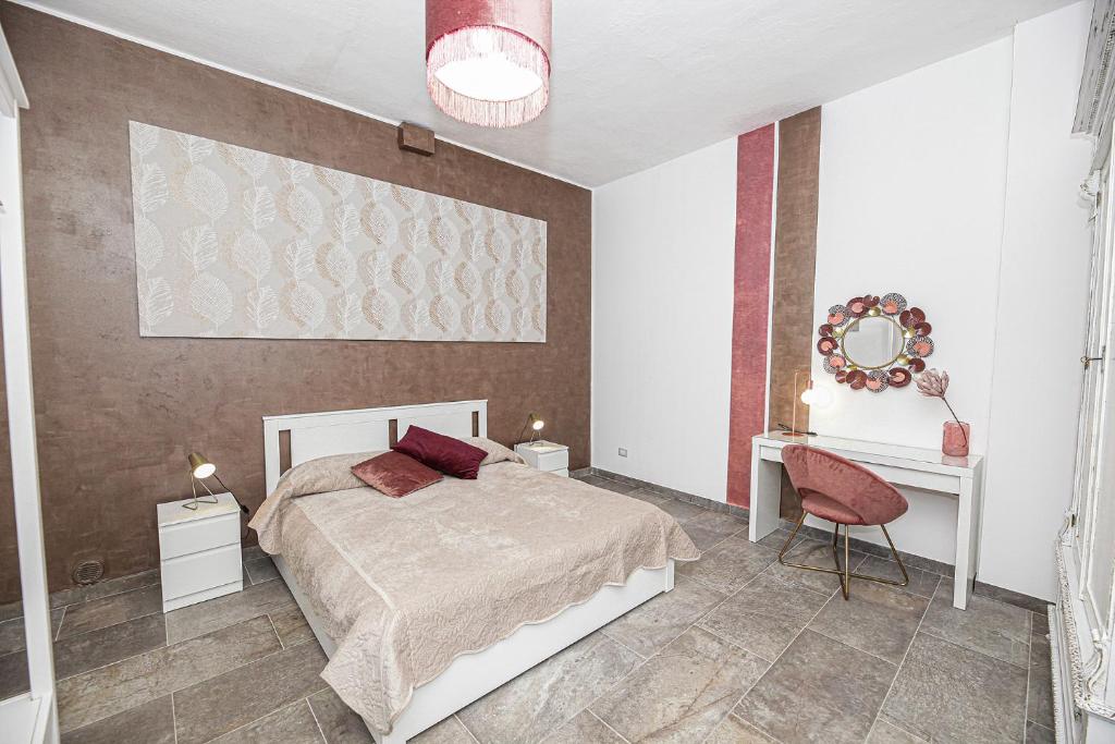 1 dormitorio con cama, mesa y espejo en Casa Raffadali, in centro storico a Palermo, en Palermo
