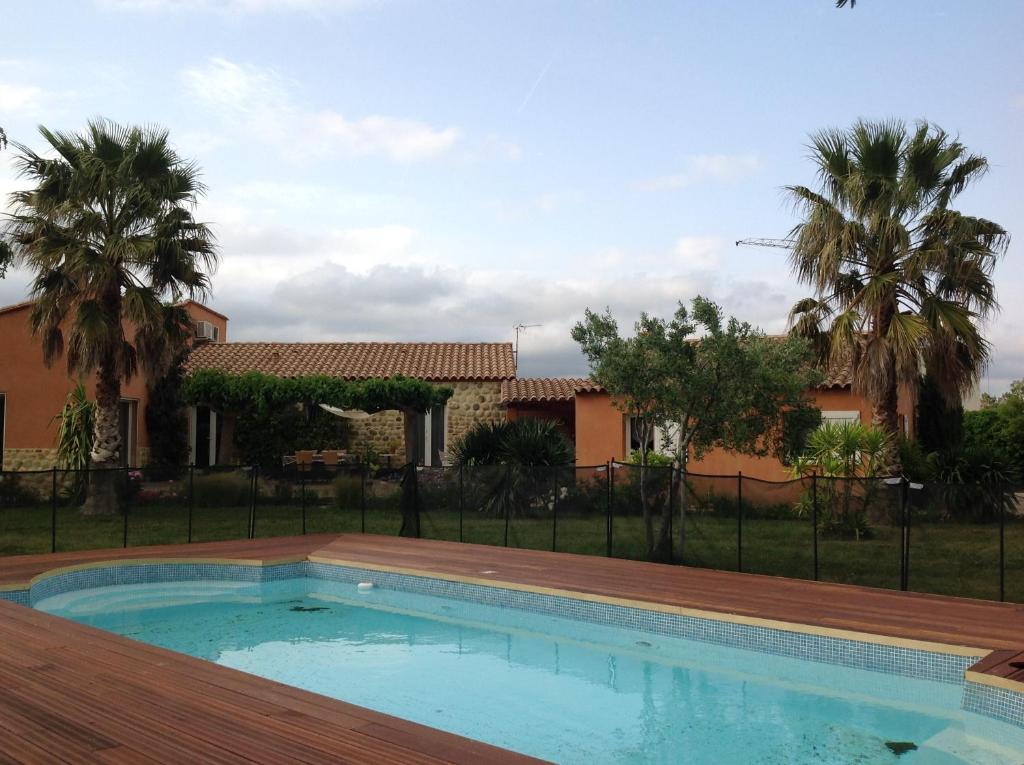 una piscina frente a una casa con palmeras en Mas Uranie en Le Soler