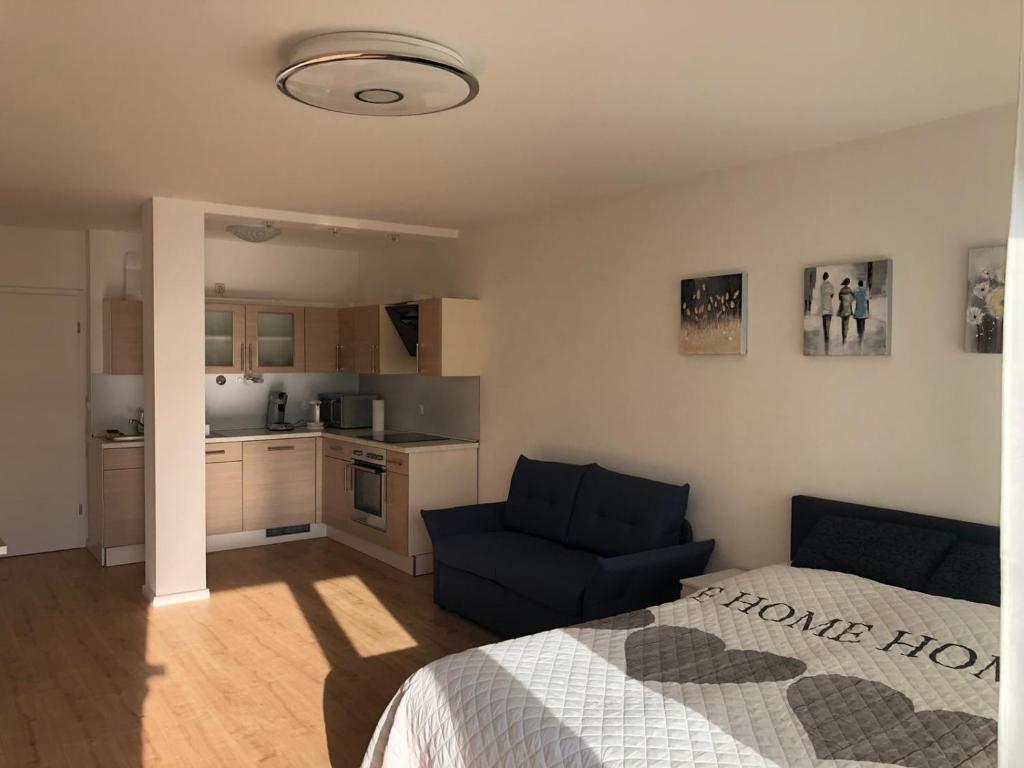 Cet appartement comprend une chambre avec un lit et un canapé ainsi qu'une cuisine. dans l'établissement Apartment Augsburg Mitte, à Augsbourg