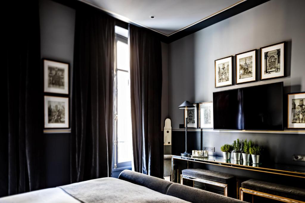 a bedroom with black walls and a bed and a window at Monsieur George Hotel & Spa - Champs-Elysées in Paris