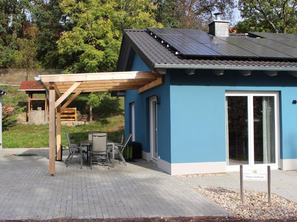 ein blaues Gebäude mit einem Dach und einer Terrasse in der Unterkunft Lifestyle Ferienhaus in Pouch