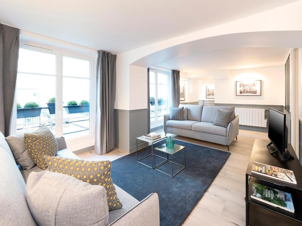 ein Wohnzimmer mit einem Sofa und einem TV in der Unterkunft LivinParis - Luxury 4 Bedrooms Le Louvre I in Paris