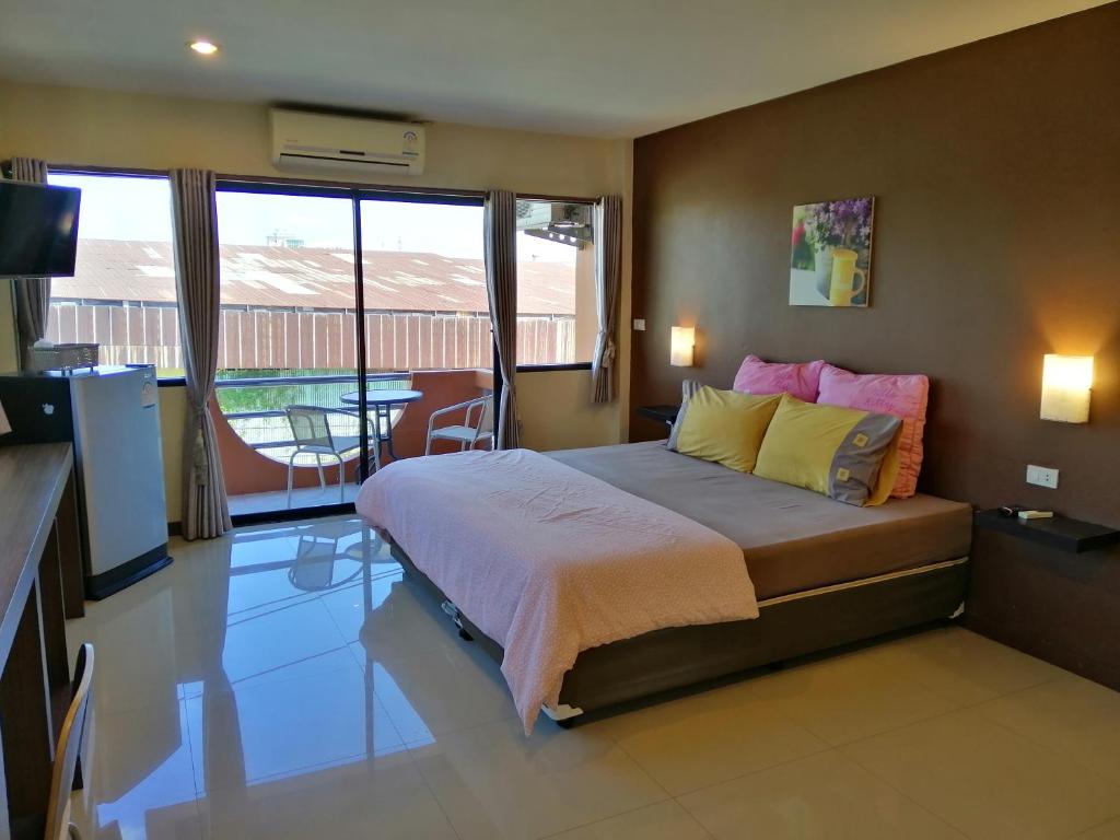 um quarto com uma cama, uma televisão e uma varanda em ศรีกรุงดีลักซ์โฮเตล em Phra Nakhon Si Ayutthaya