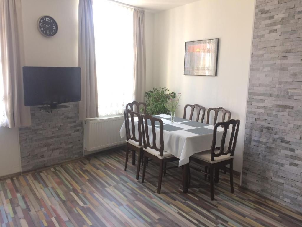 a dining room with a table and chairs and a tv at Privé appartement in de buurt van Brussel in Asse