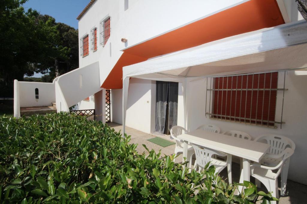 a white house with a white table and chairs at Villa Debby appartamento 01 in Rosolina Mare