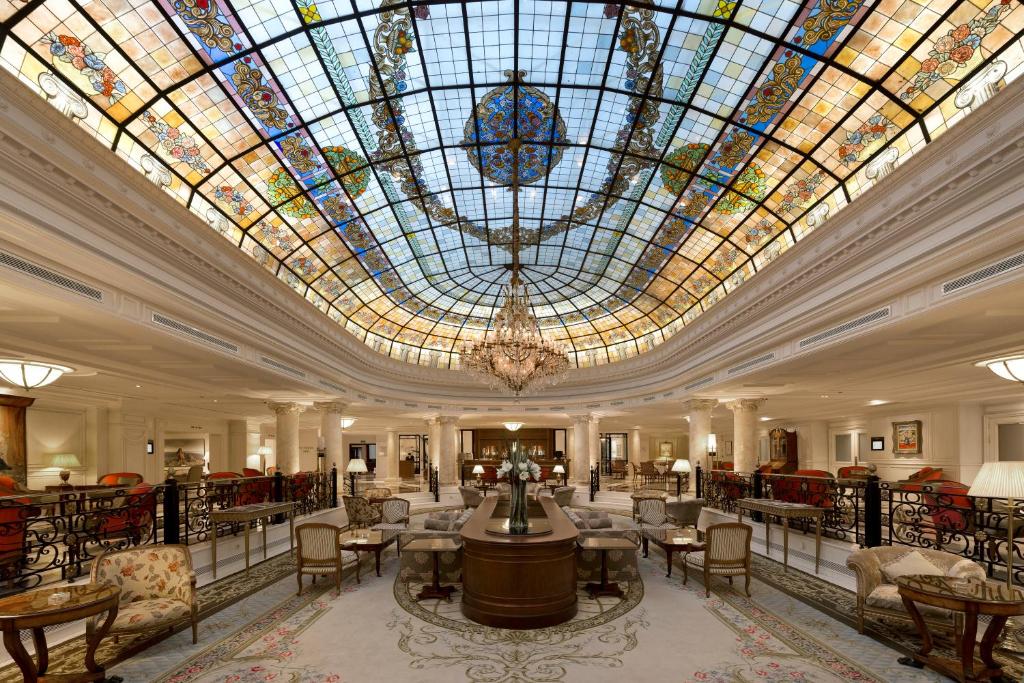 eine große Lobby mit großer Buntglasdecke in der Unterkunft Eurostars Palacio Buenavista in Toledo