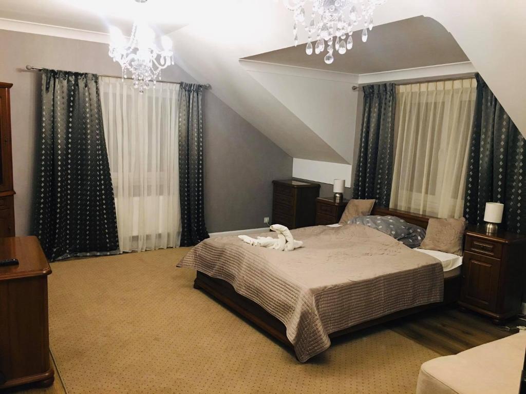 um quarto com uma cama com um cão branco em Hostel LaGoya z Restauracją em Nielisz
