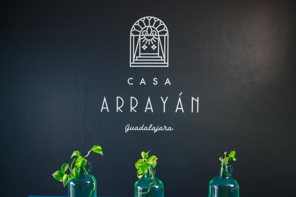 três garrafas azuis sentadas numa mesa com plantas nelas em Casa Arrayan em Guadalajara