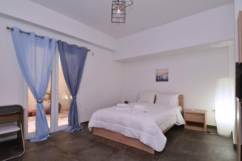 una camera da letto con un grande letto con tende blu di Koukaki, a minimal studio ad Atene