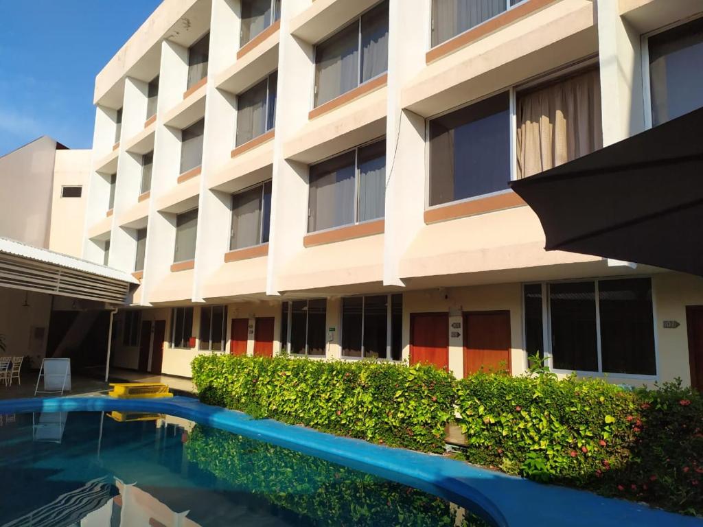 a building with a swimming pool in front of a building at Hotel Cabildos in Tapachula