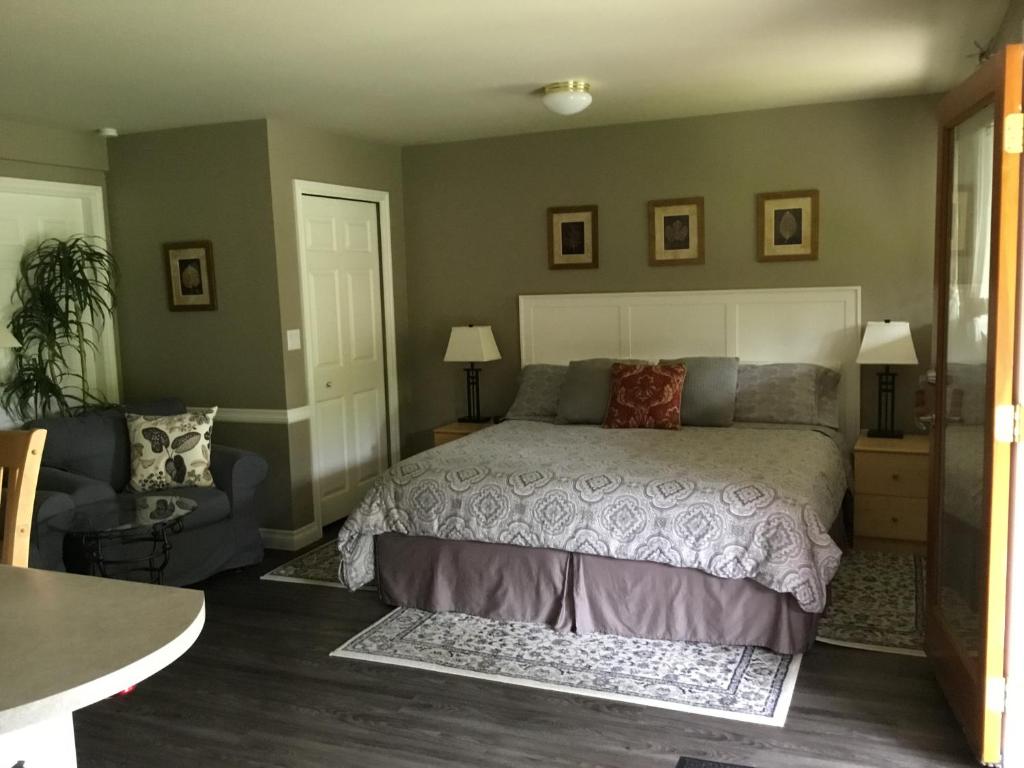 a bedroom with a bed and a couch and a chair at Nestledown B&B in Halfmoon Bay