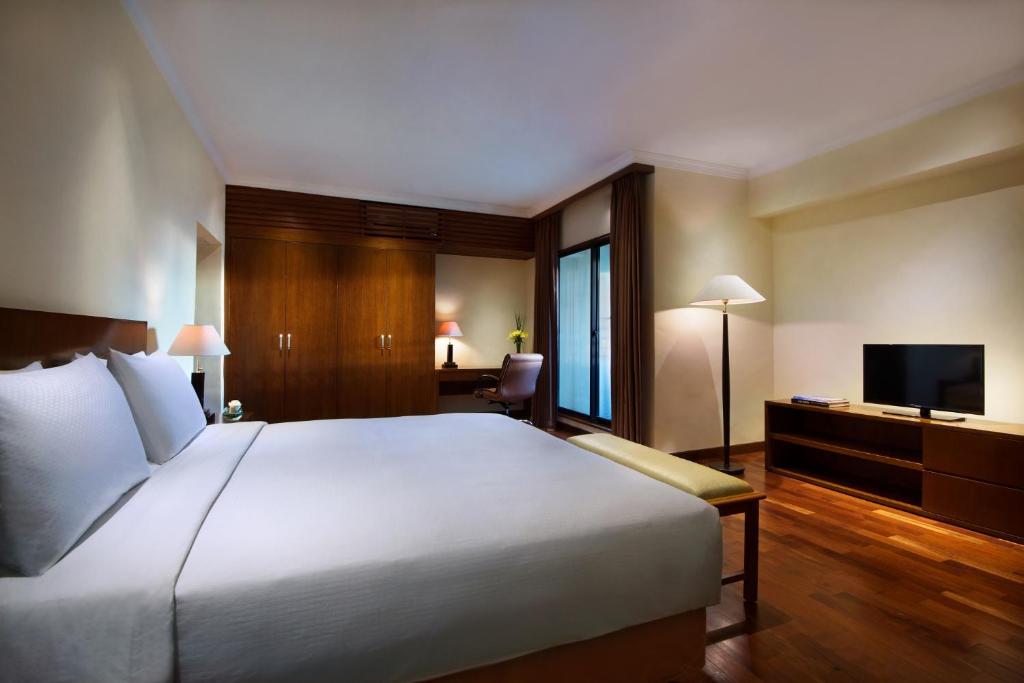 a hotel room with a large bed and a television at The Sultan Residences Jakarta in Jakarta