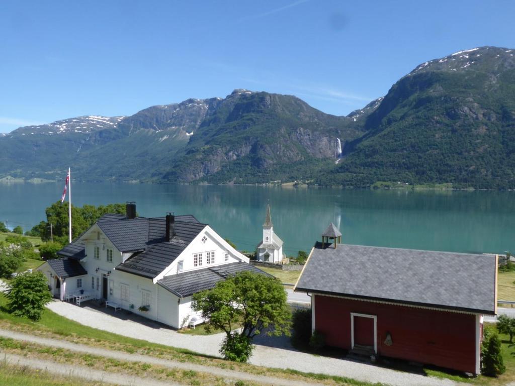 an aerial view of a house and a church next to a lake at Nes Gard in Høyheimsvik