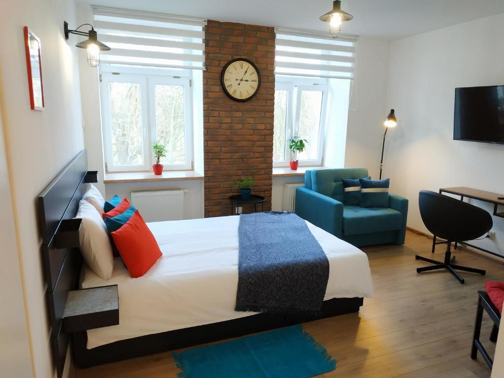 a bedroom with a bed and a clock on the wall at theApartments Radwańska in Łódź