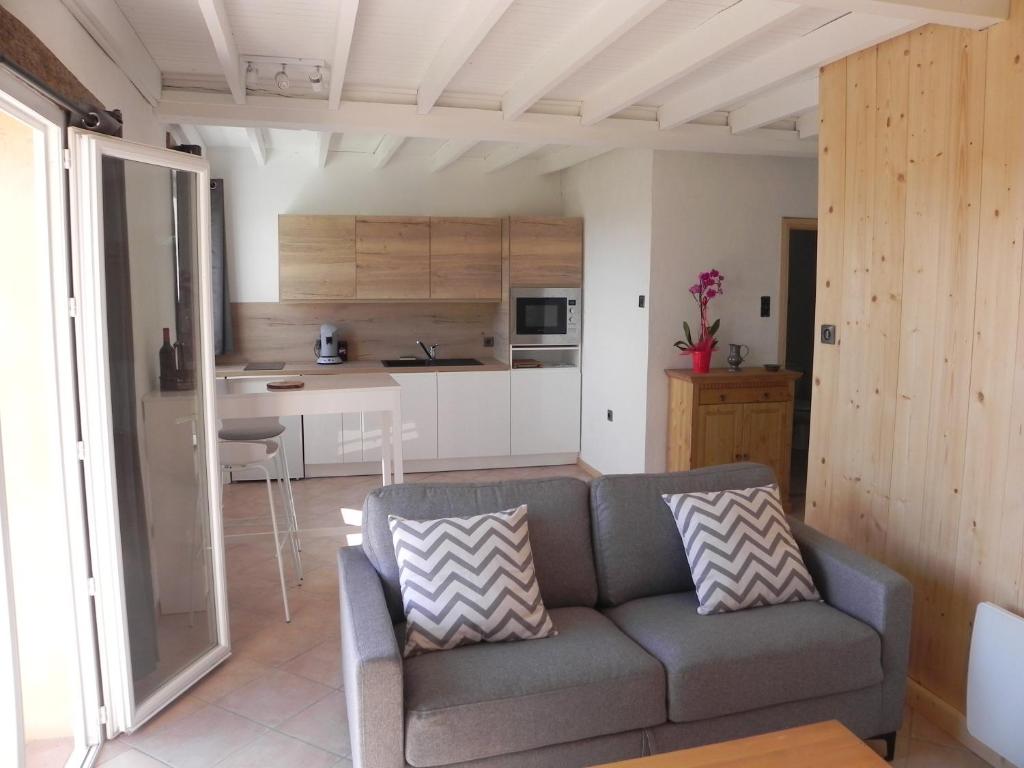 a living room with a couch and a kitchen at Figuier résidence Domaine Cap de Coste in Saint-Frajou