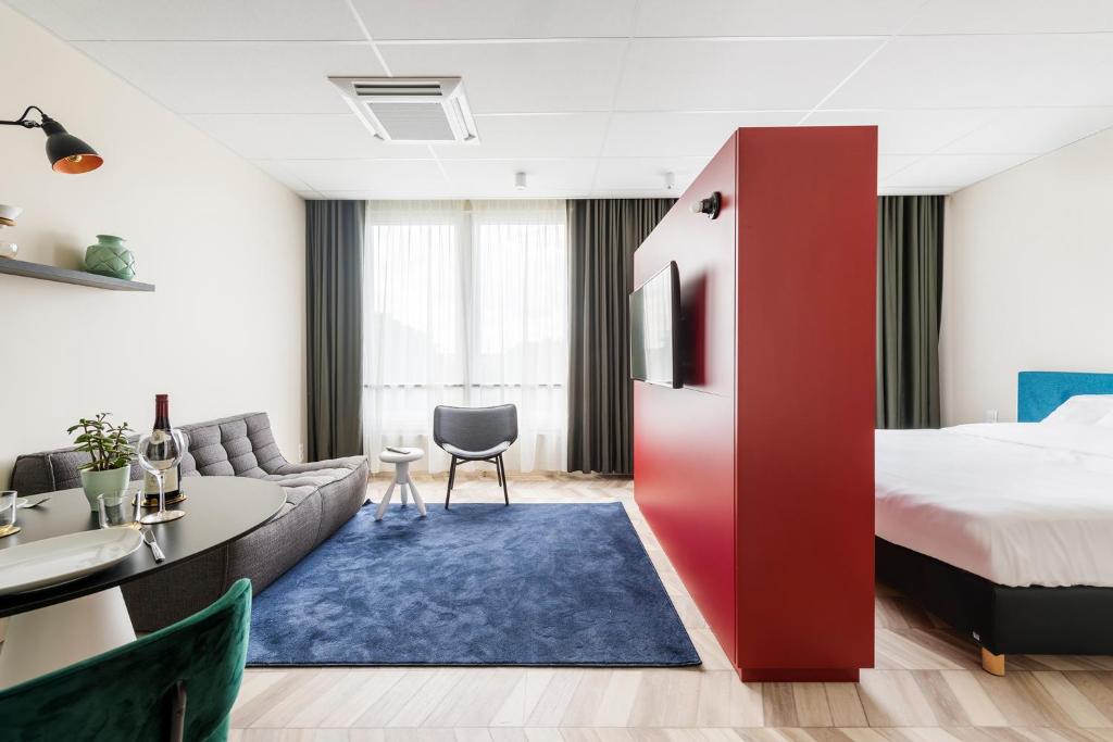Habitación de hotel con cama y sofá en ROXI The Urban Residence Brussels, en Bruselas