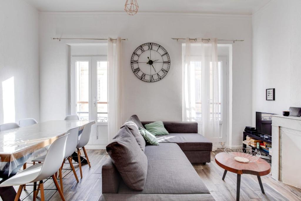 - un salon avec un canapé, une table et un réveil dans l'établissement Marseille - hyper centre- Docks Joliette - maxi 8p, à Marseille
