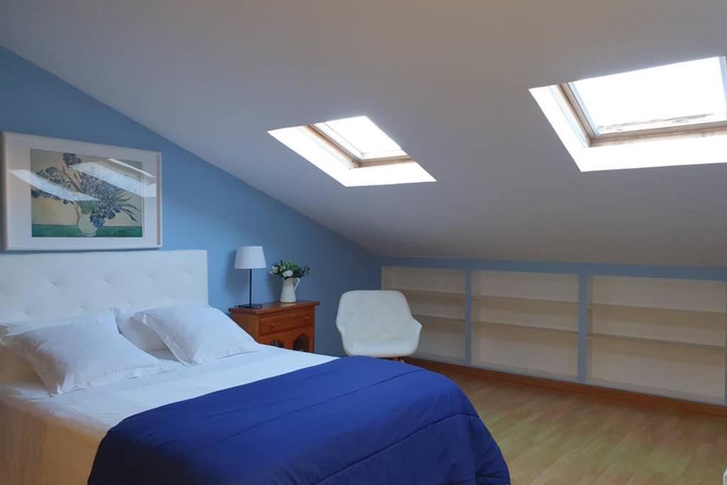 um quarto com uma cama e clarabóias no tecto em Ático muy luminoso con Parking, em Zaragoza