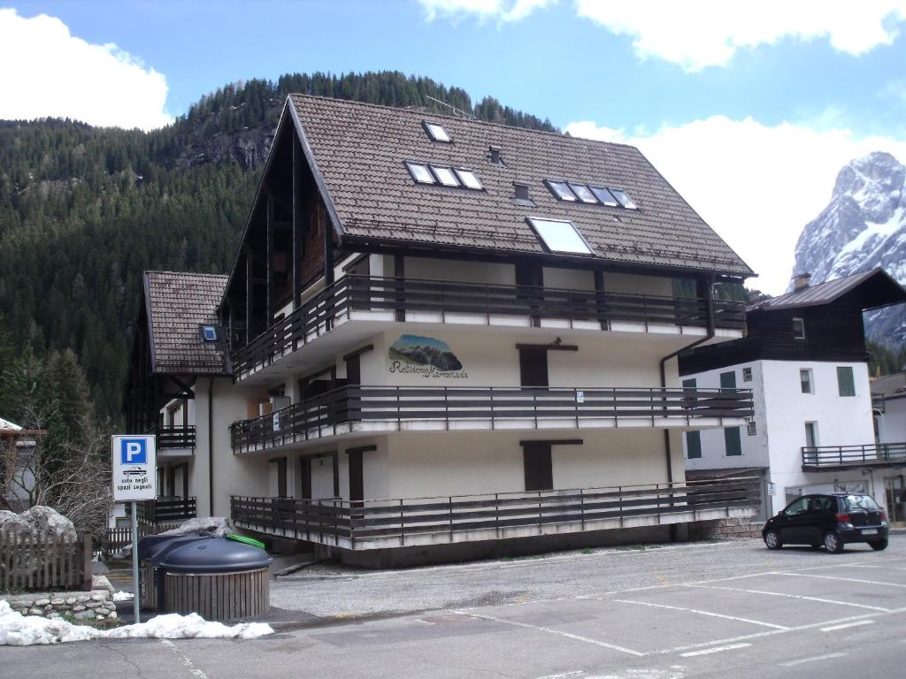 a large building with a mountain in the background at Appartamento MARMOLADA - CANAZEI in Canazei