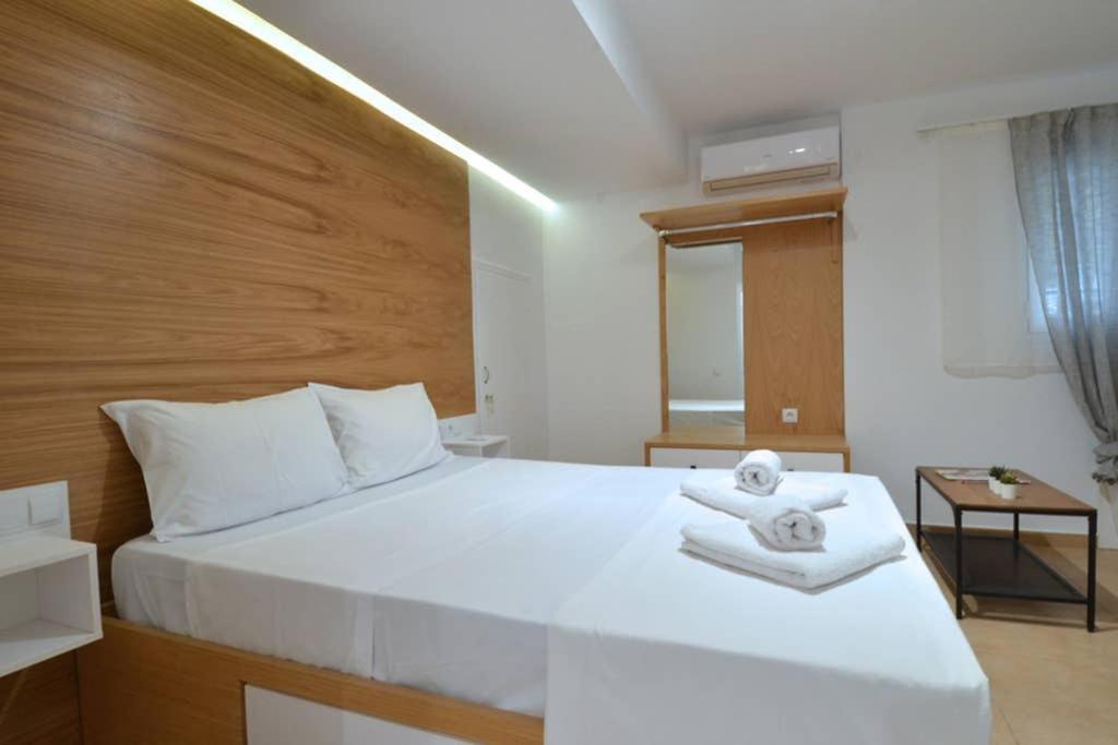 1 dormitorio con 1 cama blanca grande y toallas. en Acropolis, a nice and minimal apartment en Atenas