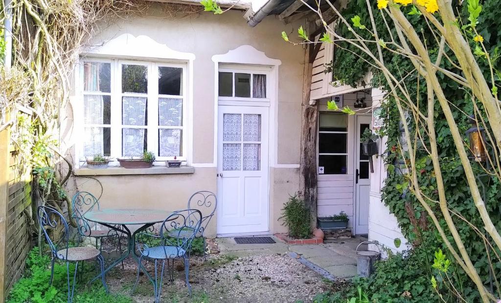 a small garden with a table and chairs in front of a house at Ferme de l'Art Rural et Populaire in Maillot