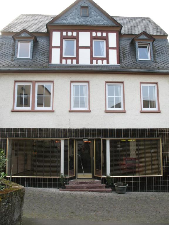 a large white and red house with windows at Moselhaus Tante Emma in Pünderich