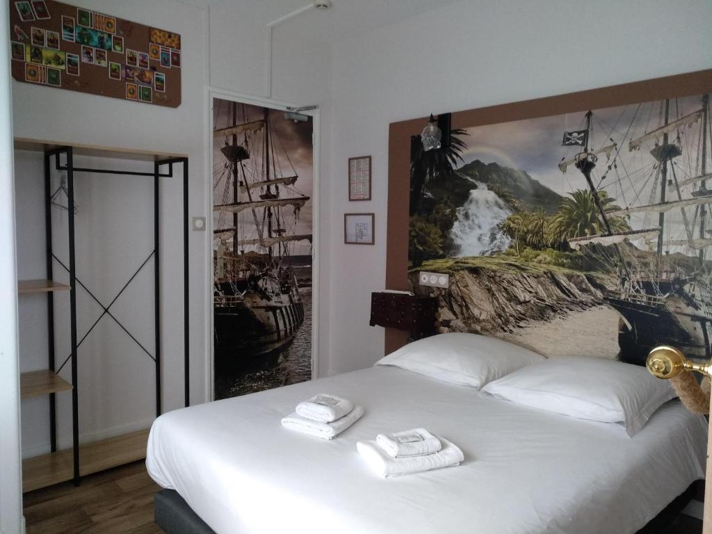 a bedroom with a bed with two towels on it at Hotel Angelys in Ploërmel