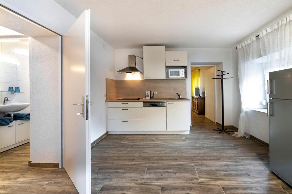 una cucina con armadietti bianchi e pavimenti in legno di Marinas Ferienwohnungen a Vordernberg