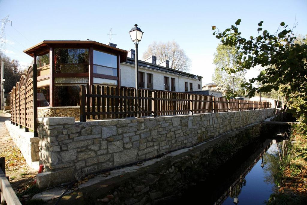 una casa en una pared de piedra junto a un canal en Posada Real La Yensula en El Puente