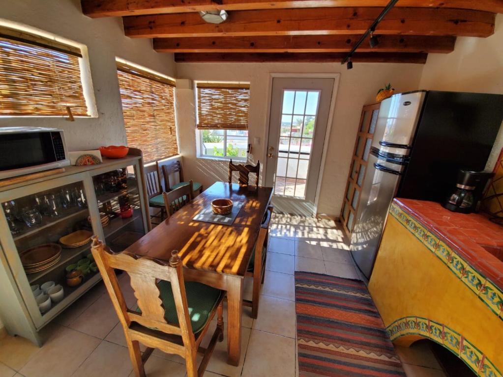 a kitchen with a wooden table and a refrigerator at Pied à Terre at Casitas Aparicio in San Miguel de Allende