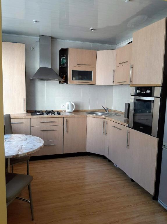 a kitchen with white cabinets and a table in it at Irene apartments in Druskininkai
