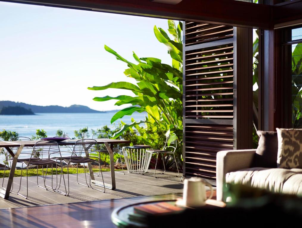 ein Wohnzimmer mit einem Sofa, einem Tisch und Stühlen in der Unterkunft Yacht Club Villas in Hamilton Island