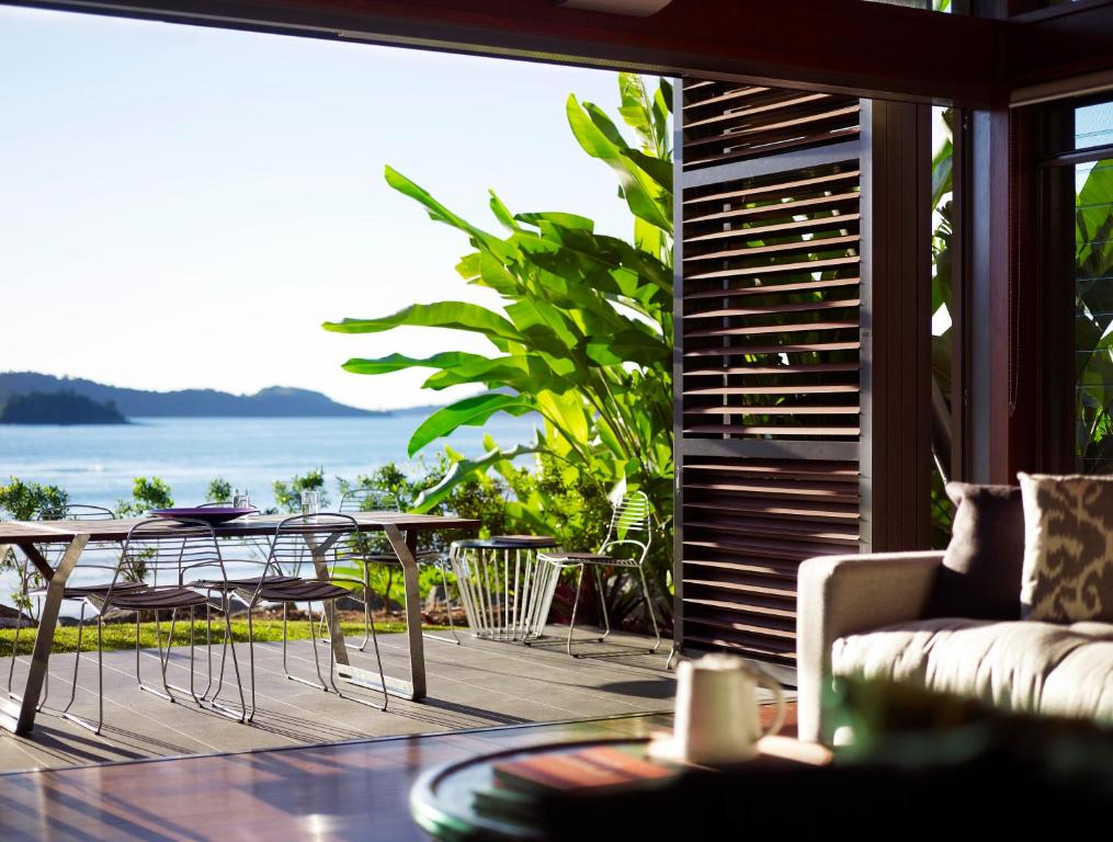 a living room with a couch and a table and chairs at Yacht Club Villas in Hamilton Island