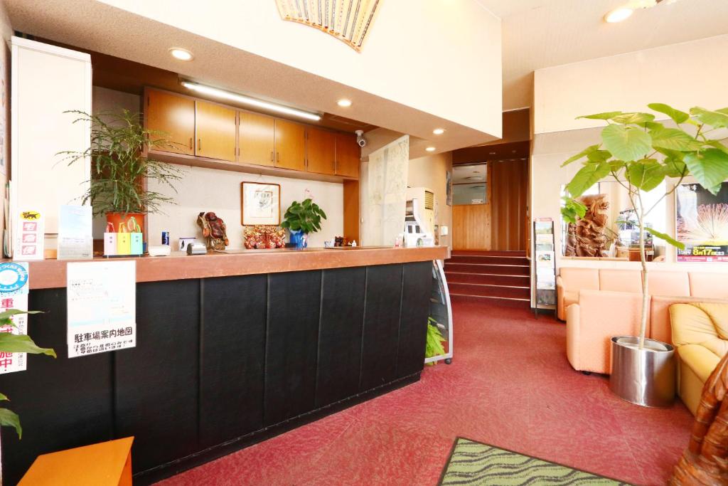 una hall di un hotel con bancone e piante di Business Hotel Miharashitei a Kumano