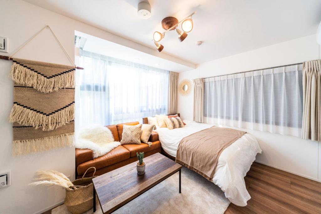 a bedroom with a bed and a couch and a window at GIVE Araiyakushi in Tokyo