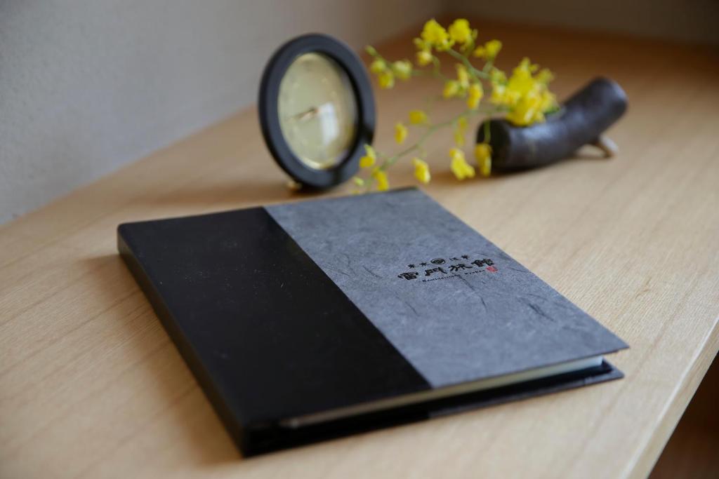 un livre assis sur une table avec une loupe dans l'établissement Kaminarimon Ryokan, à Tokyo