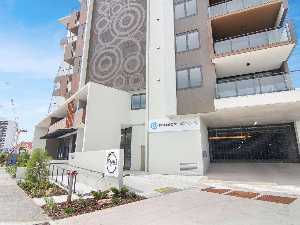 an apartment building with a garage in front of it at Direct Collective - Rhythm on Beach in Maroochydore