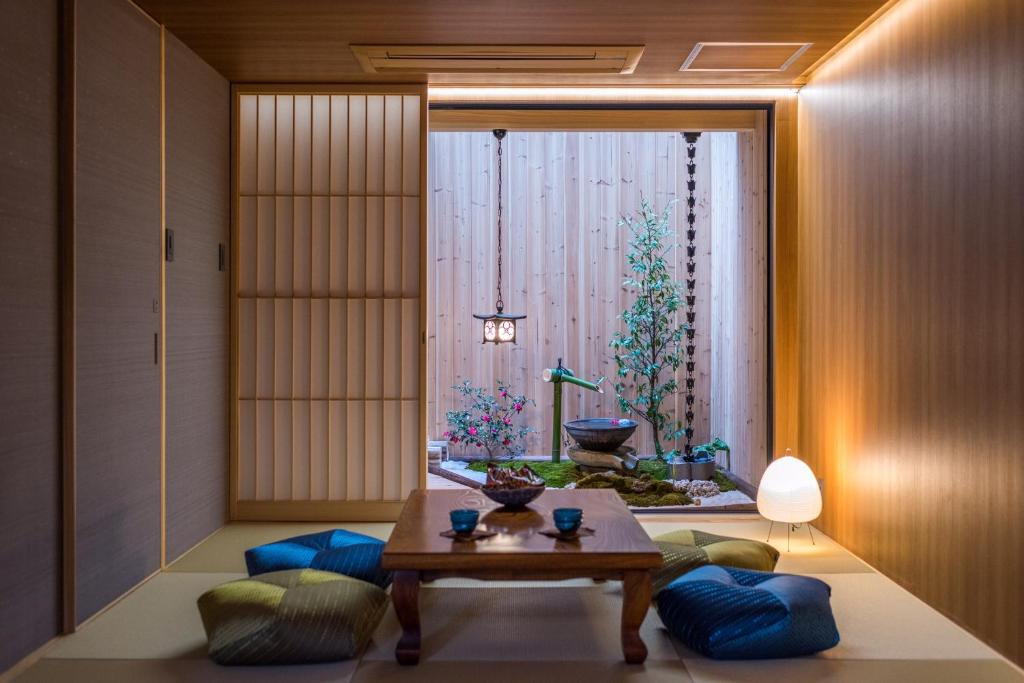 uma sala de estar com uma mesa e uma grande janela em TABITABI STAY MOONLIGHT em Quioto