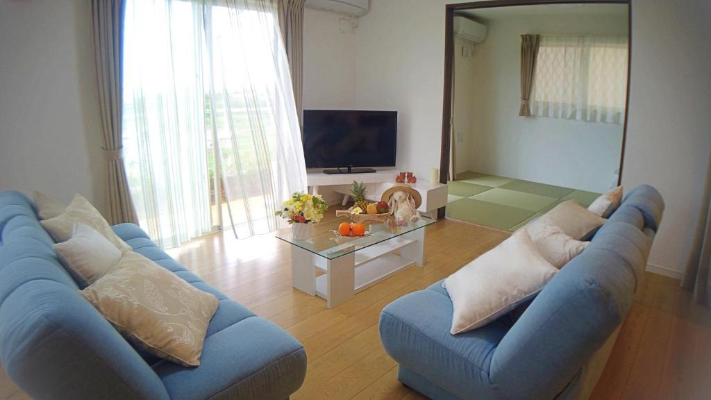 sala de estar con sofá azul y TV en Ecot Shimozato 1, en Isla Miyako