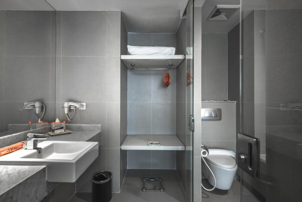 ein kleines Bad mit einem Waschbecken und einem WC in der Unterkunft HARRIS Hotel & Conventions Malang in Malang