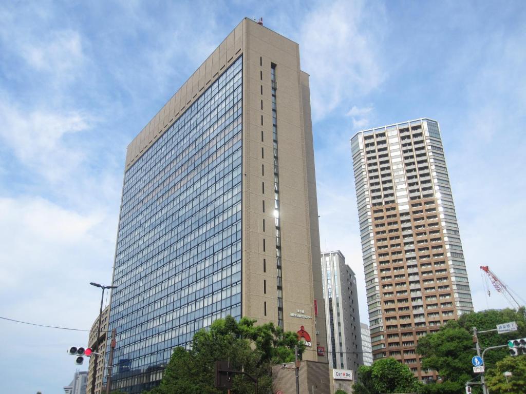 a tall building in a city with two tall buildings at Tokyo Central Youth Hostel in Tokyo