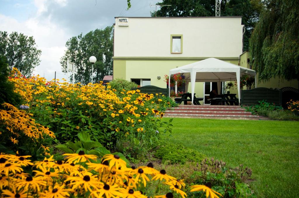 ein Haus mit vielen Blumen im Hof in der Unterkunft Ferrara B&B Motel in Wągrowiec