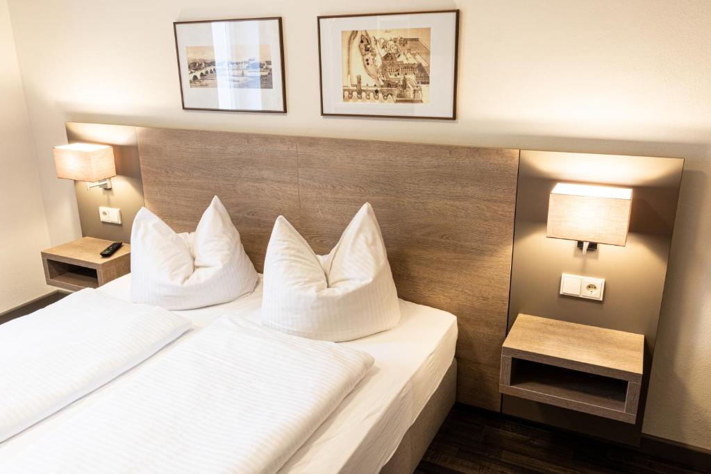 レーゲンスブルクにあるBrauereigaststatte Spitalgartenのホテルルーム(白い枕2つ付きのベッド1台付)