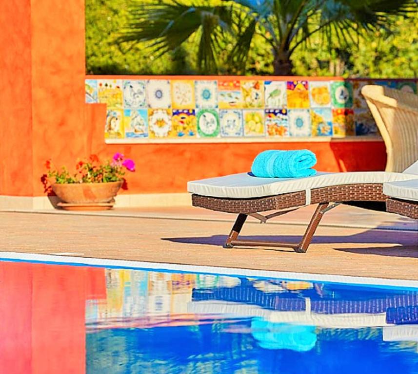 una piscina con chaise longue y toalla en Dimora A' Turri di GN Real Escapes, en Ribera