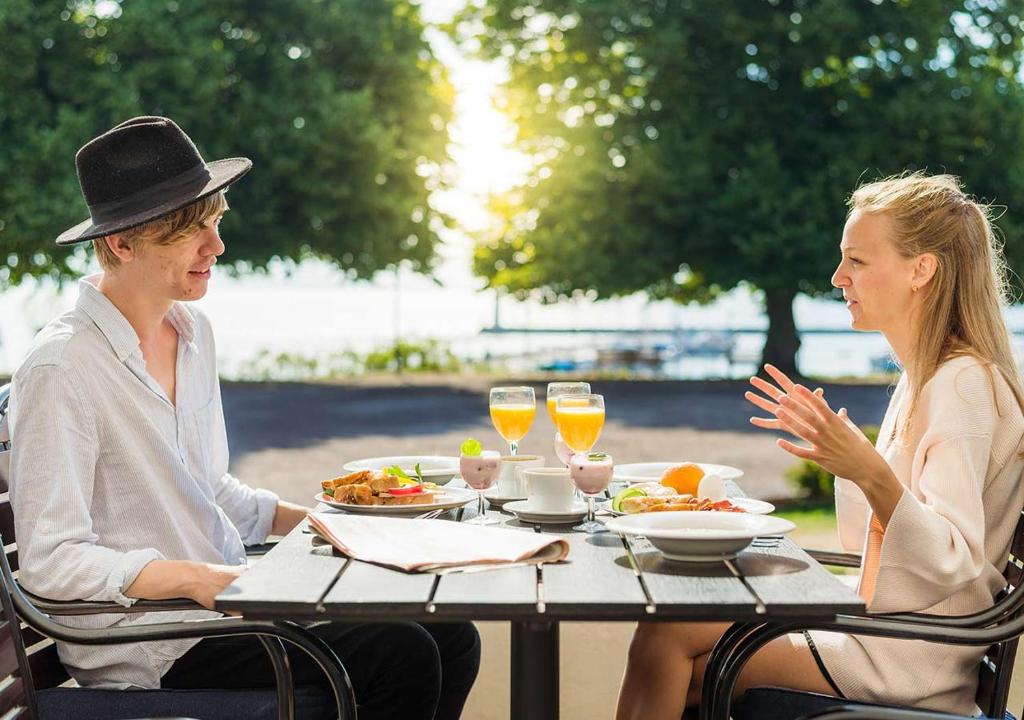 a woman sitting at a table with a man at Hotel Bellevue in Hjo
